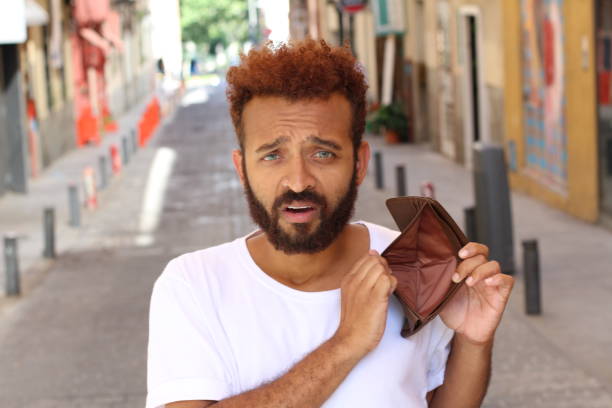 istock Ethnic broke guy with empty wallet outdoors 991031666