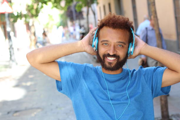 funky ethnischen mann anhören von musik - men latin american and hispanic ethnicity young men smiling stock-fotos und bilder