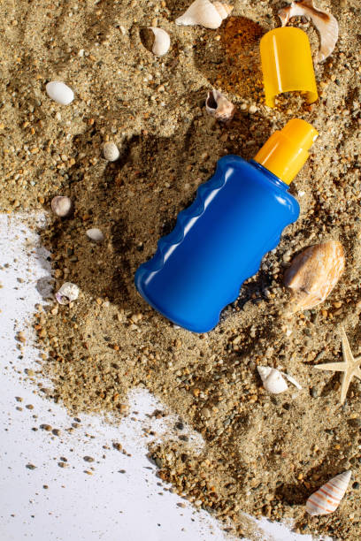 istock Bottled suntan spray on the sand 991040730