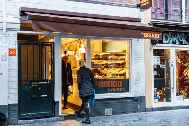 Amsterdam, Netherlands - December 15, 2017: Woman is buying cakes in a shop in Zeedijk  in Amsterdam. View through window