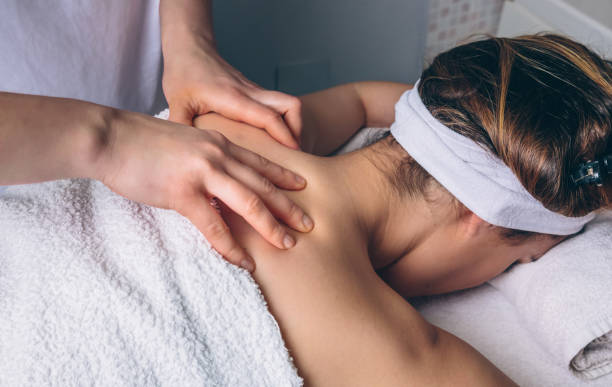 Woman receiving relaxing back massage on clinical center Close up of young woman receiving a relaxing back massage on clinical center. Medicine, healthcare and beauty concept. lymphatic system stock pictures, royalty-free photos & images