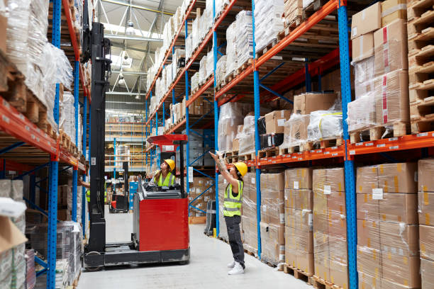 istock Female worker driving on a forklift. Warehouse 991053396
