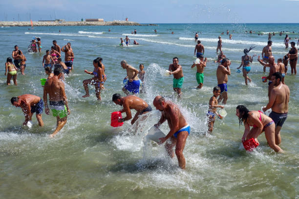 Nettuno, Italy - Aug 2015: people having fun with fight of water at sea at ferragosto holiday