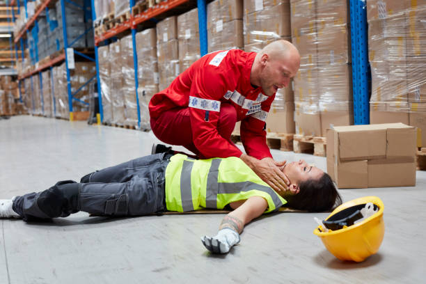 Dangerous accident during work. Paramedic gives first aid Woman lyingon the floor. Accident in warehouse rescue services occupation stock pictures, royalty-free photos & images