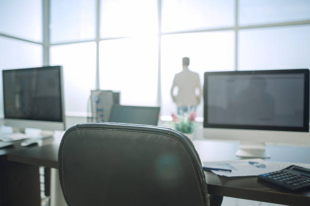 istock Modern office space with tables and office supplies 991058494