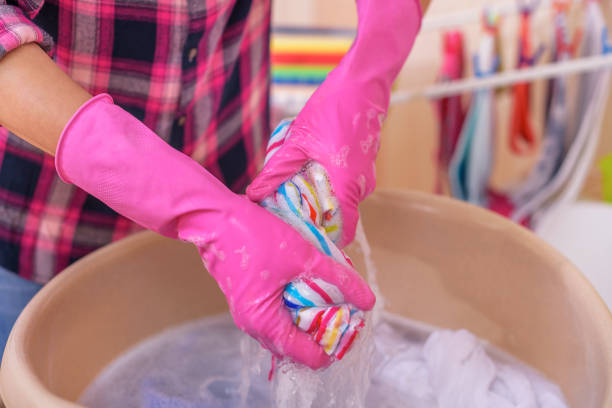 istock Women's hands wash clothes in the basin. 991064470
