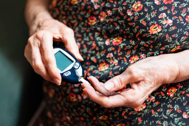 alte dame tracking ihr blutzuckerspiegel. gesundheitskonzept - diabetes blood illness chronic stock-fotos und bilder