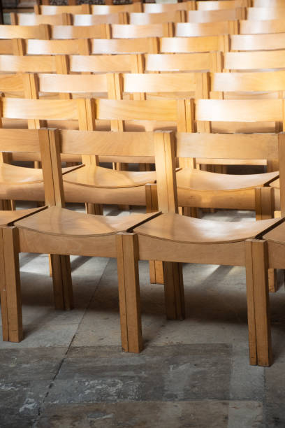 istock Plain wooden chairs in rows inside Church 991078356