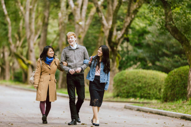 istock Three multinational lovers or friends walking in the fresh green park 991079290