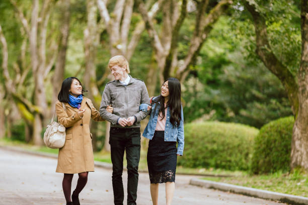 istock Three multinational lovers or friends walking in the fresh green park 991079394