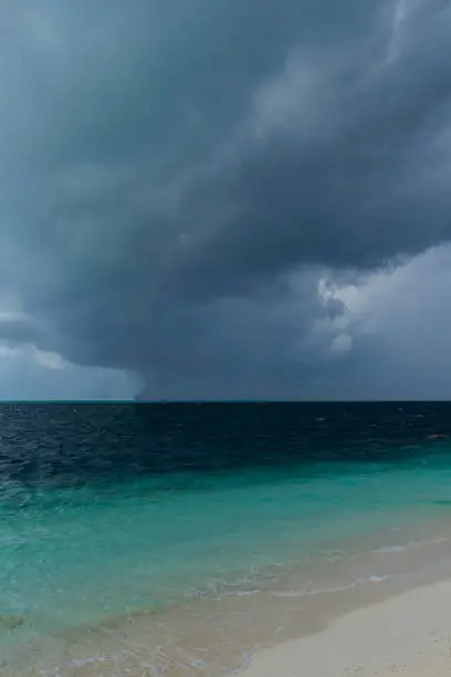 Photo of Dark hurricane cloud above tropical sea