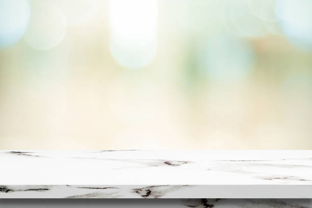 istock Empty white marble table over blur store background, product display montage 991084648