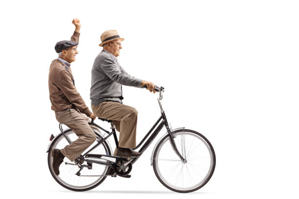 istock Two cheerful elderly men riding a bicycle together 991107898
