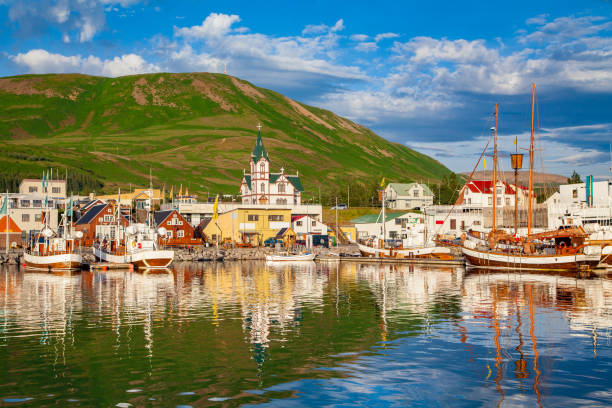 Town of Husavik at sunset, north coast of Iceland Scenic view of the historic town of Husavik in beautiful golden evening light at sunset with blue sky and clouds, north coast of Iceland akureyri stock pictures, royalty-free photos & images