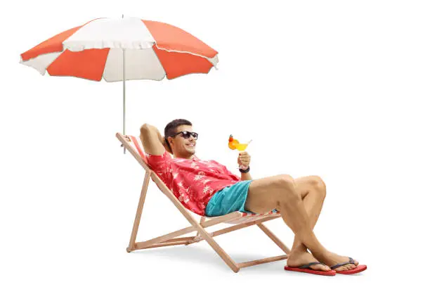 Photo of Tourist with a cocktail sitting in a deck chair with an umbrella