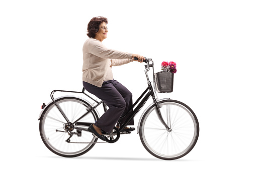 Mature woman riding a bicycle isolated on white background