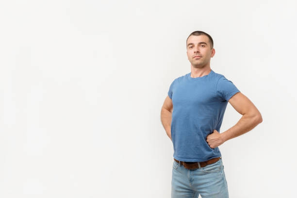 Handsome young man standing like a super hero Handsome young man standing like a super hero. He is proud of himself physical position stock pictures, royalty-free photos & images