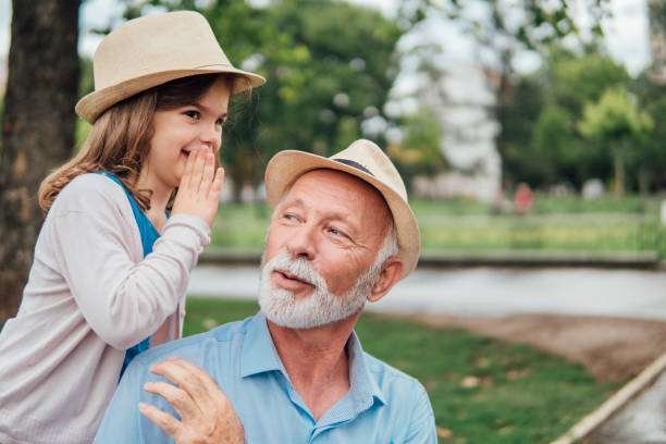istock Young girl whispering to her grandfather 991114596