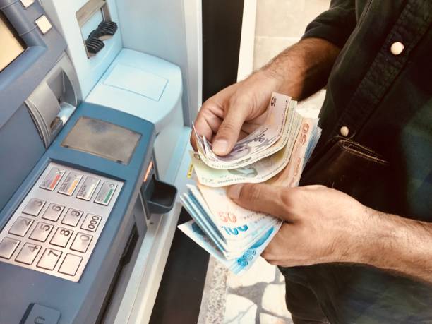 トルコ男の atm にお金を与える手 - エレクトロニックバンキング ストックフォトと画像