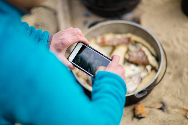Man taking a picture of the lunch he cooked over a fire