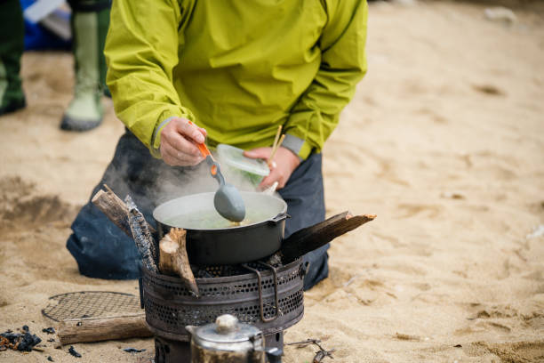 Close up of people cooking outdoors while camping
