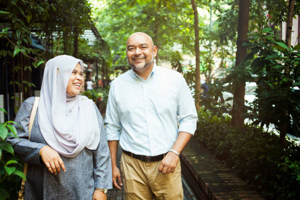 istock Asian couple smiling and laughing while walking in downtown 991129540