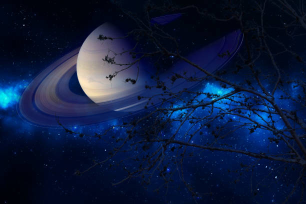 istock Saturn near earth on night sky back silhouette dry tree 991130858