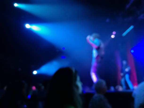 istock Defocused abstract blurred scene of musical light performance in a concert on stage with crowd 991136138
