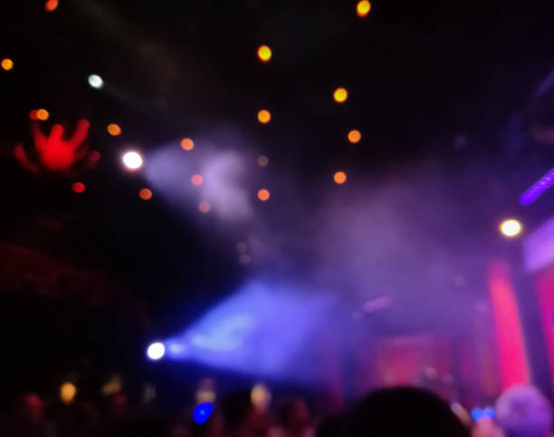 istock Defocused abstract blurred scene of musical light performance in a concert on stage with crowd 991136768