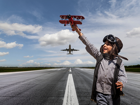 Boy playing with toy airplane on runway