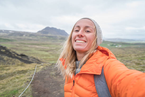 istock Young woman taking selfie at volcano area, Iceland 991149372