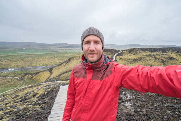 istock Young man taking selfie at volcano area, Iceland 991149808