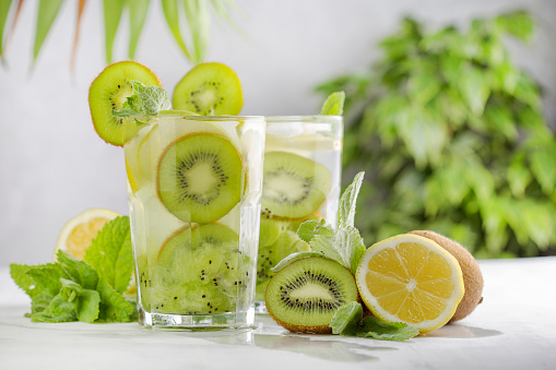 tropical cocktail with kiwi, lemon and mint on light background