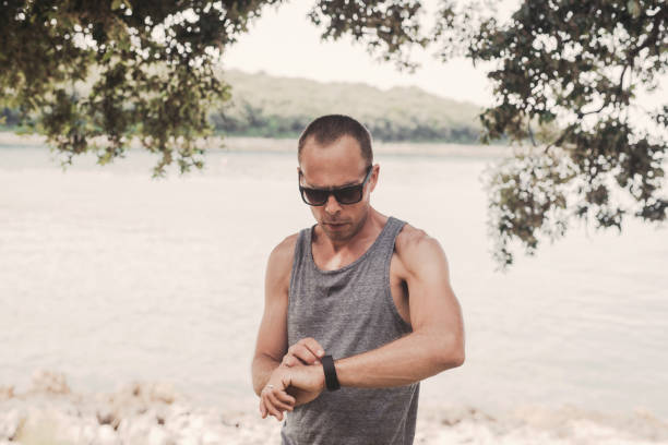 istock Man outdoors in sunny summer day with tank top and sunglasses 991155100