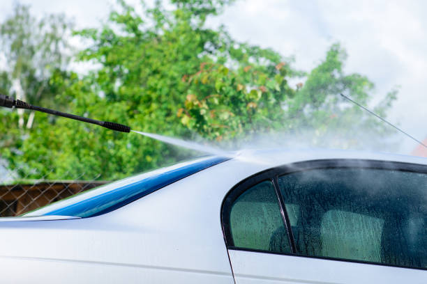 istock Unidentified man worker washing car under high pressure water ou 991160820