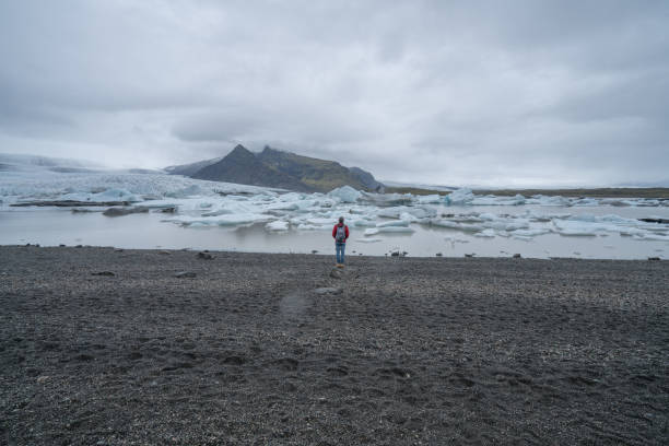 istock Young man contemplating glacier lake in Iceland 991161262