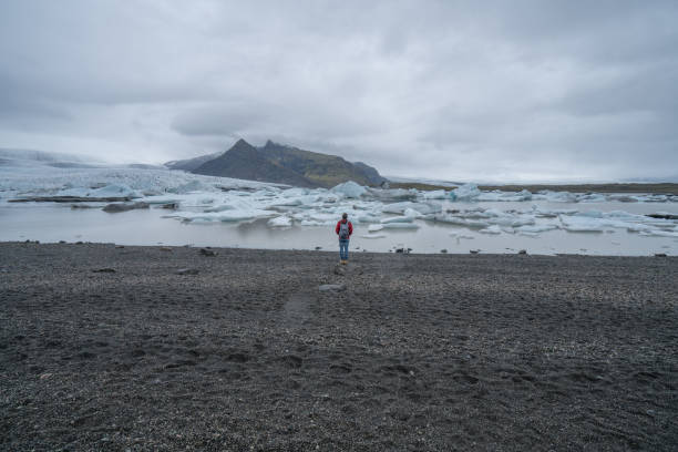 istock Young man contemplating glacier lake in Iceland 991161274