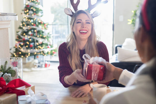 istock Female friends exchanging Christmas presents 991164854