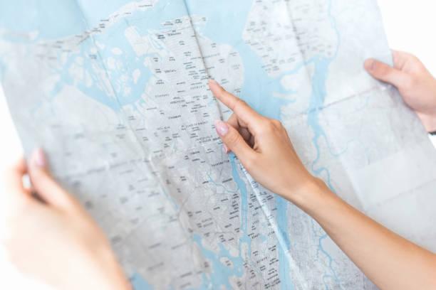 istock partial view of tourists pointing at map, isolated on white 991174258