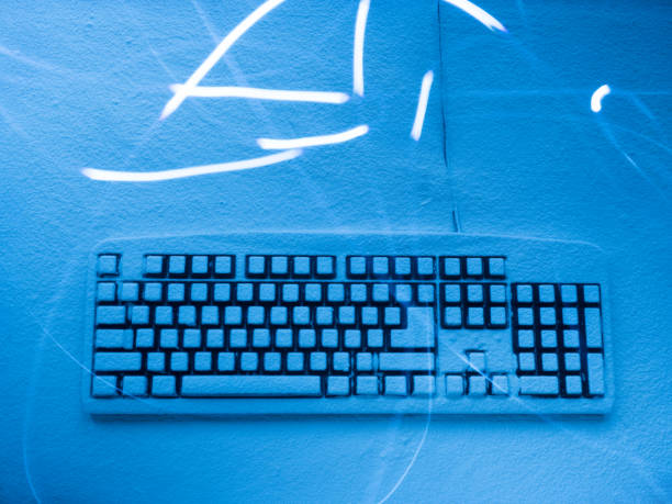 istock computer keyboard covered with blue illuminated snow with random traces from light painting 991175902