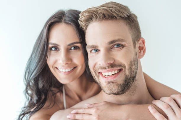 istock beautiful smiling couple looking at camera, isolated on white 991180306