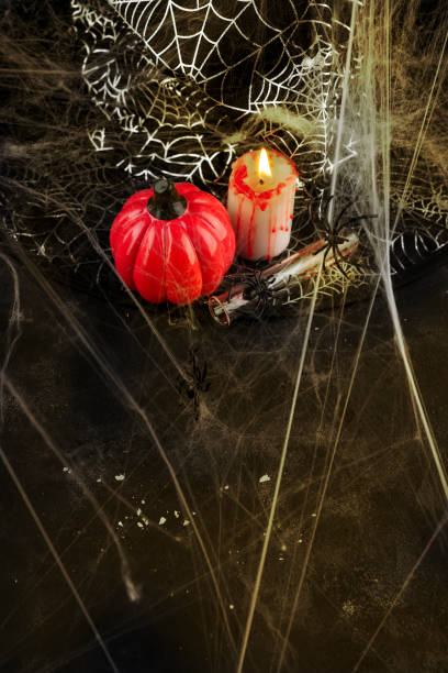 istock Pumpkin, candle and a long glass with a red cocktail 991189328