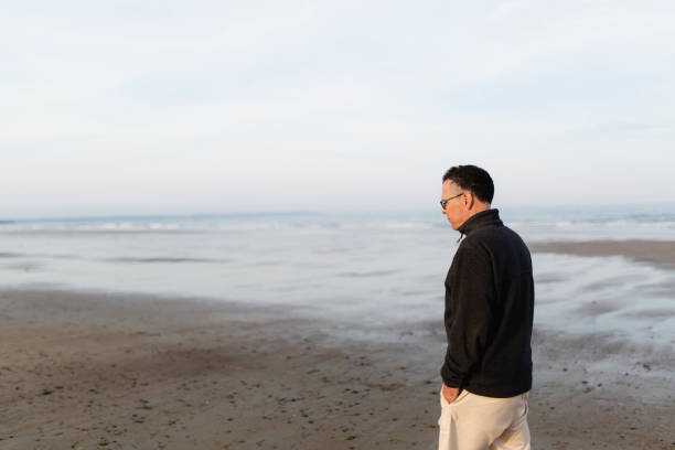 istock Man walking on the beach, Maine beach, USA 991189874