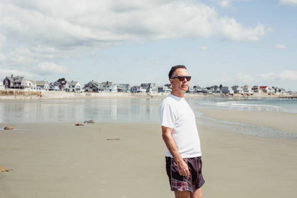 istock Man walking on the beach, Maine beach, USA 991190302