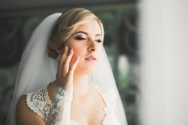 istock Gorgeous bride in robe posing and preparing for the wedding ceremony face in a room 991190552