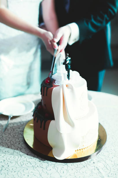 istock Bride and groom at wedding cutting the wedding cake 991198140