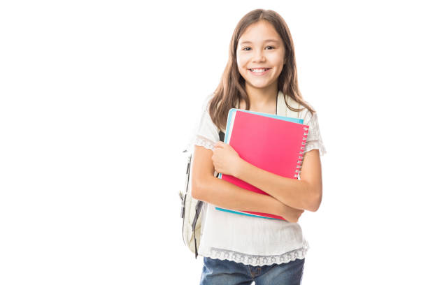 Young hispanic student girl holding books Portrait of smiling school girl child with school bag and books isolated on a white background schoolgirl stock pictures, royalty-free photos & images