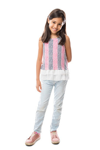 Full length image of Happy young latin girl in jeans and top posing and looking at the camera over white background