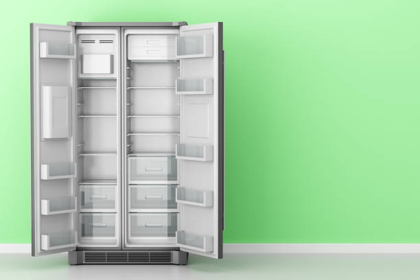 istock open empty fridge in front of green wall 991215878