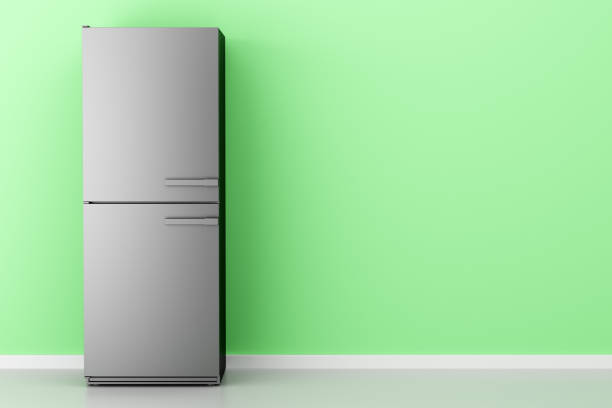 istock open empty fridge in front of green wall 991216286